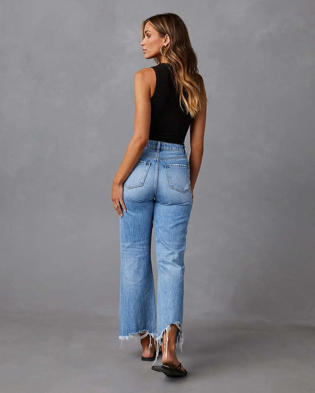 Женские рваные расклешенные джинсы High Waisted с потертым подолом — фото 4