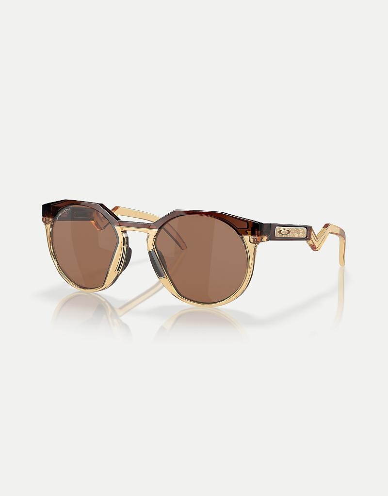 

Коричневые круглые солнцезащитные очки Oakley Kylian Mbappé Signature Series HSTN с зеркальными линзами темно-янтарного цвета/светлого карри