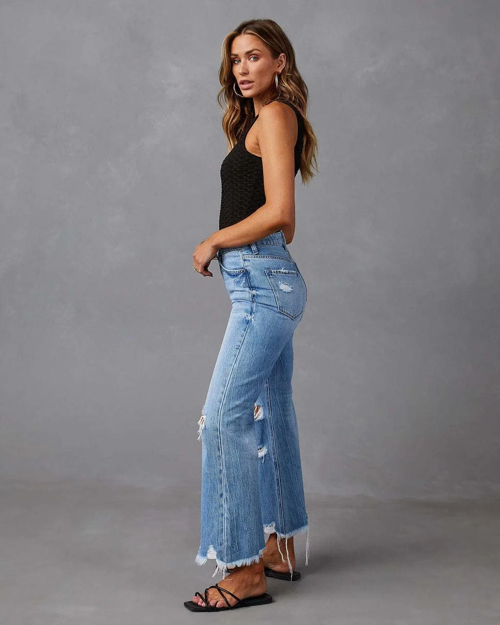 Женские рваные расклешенные джинсы High Waisted с потертым подолом — фото 3