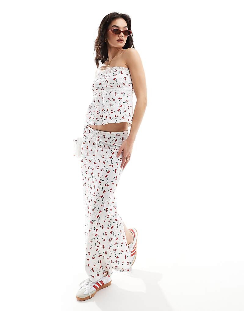 

ASOS Design – Юбка-колонна с вышивкой-люверсами, вишневым принтом и завязывающимся бантом