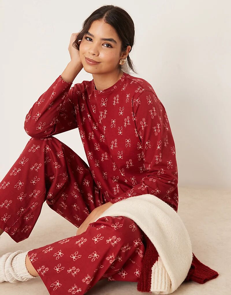 

Пижамный комплект из топа и брюк с принтом в виде красного банта ASOS DESIGN