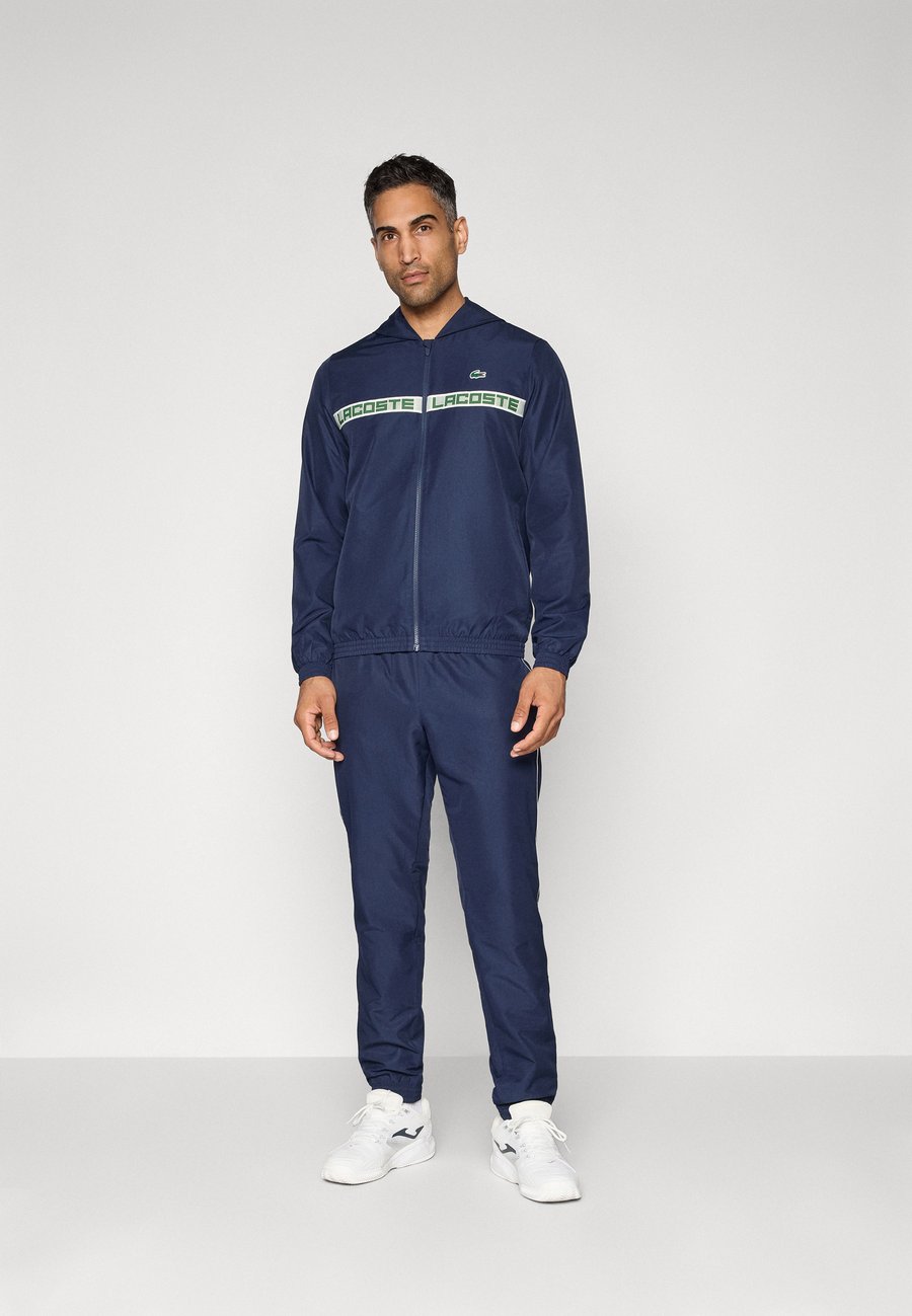 

Спортивный костюм Lacoste Sport TENNIS TRACKSUIT HOODED SET, Navy Blue/Dark Blue